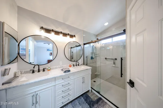 a bathroom with a double vanity sink mirror and bathtub