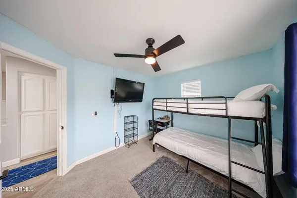 a bedroom with furniture and a ceiling fan