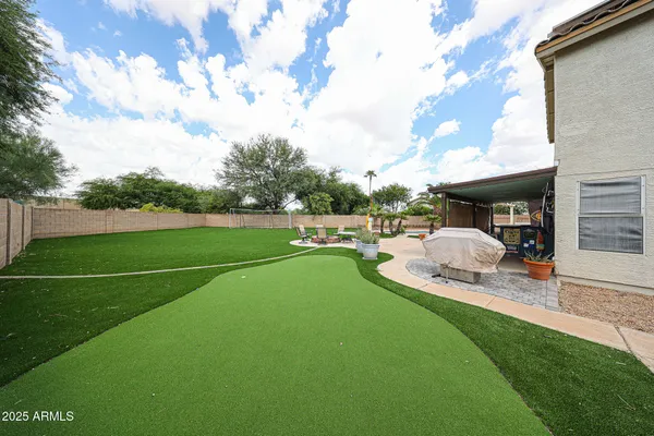 a view of a patio with table and chairs potted plants and a palm tree