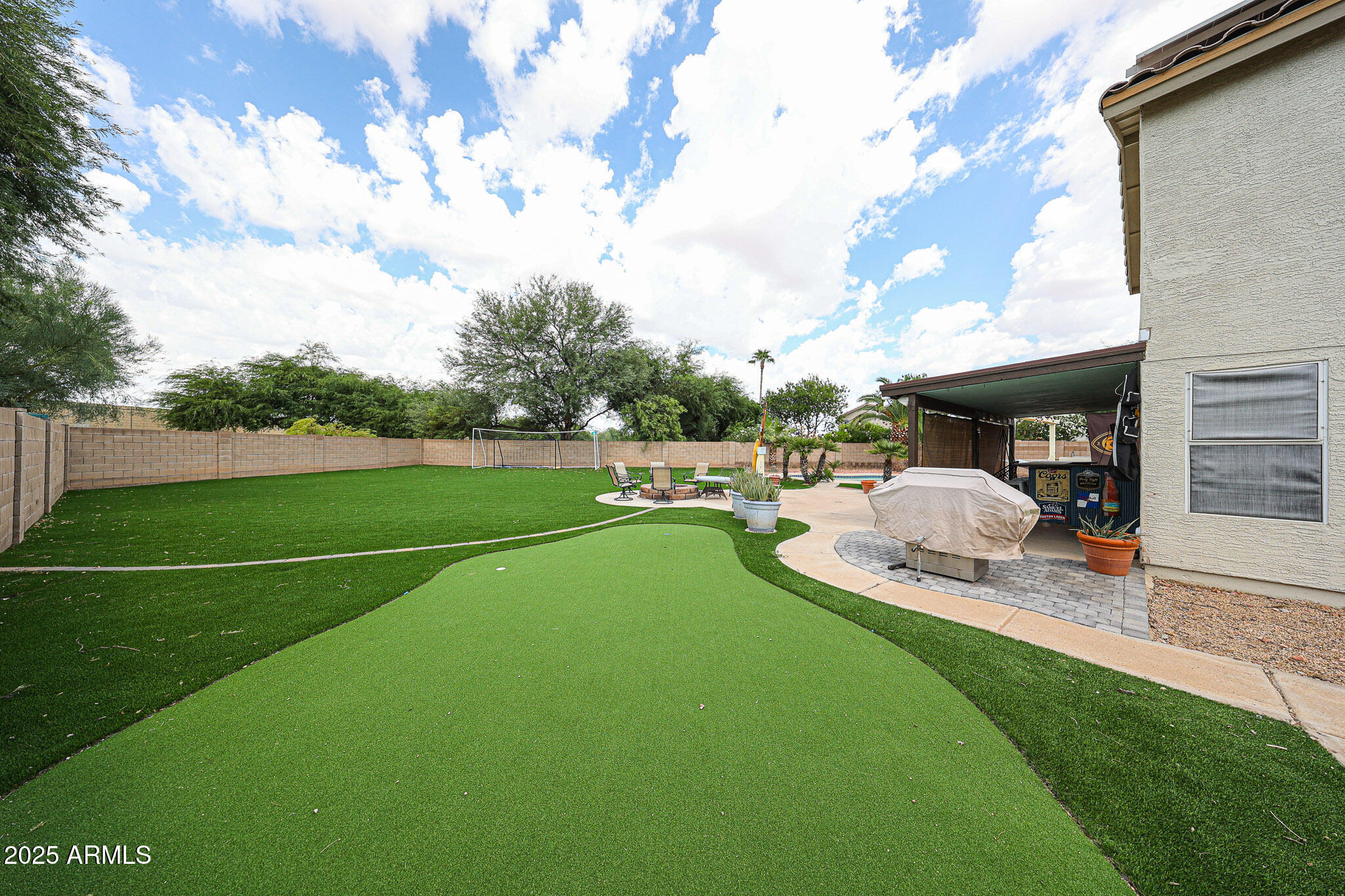 3902 East Rosemonte Drive Phoenix, AZ 85050 - Photo 34 of 46 a view of a patio with table and chairs potted plants and a palm tree