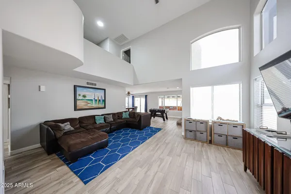 a living room with furniture kitchen view and a window