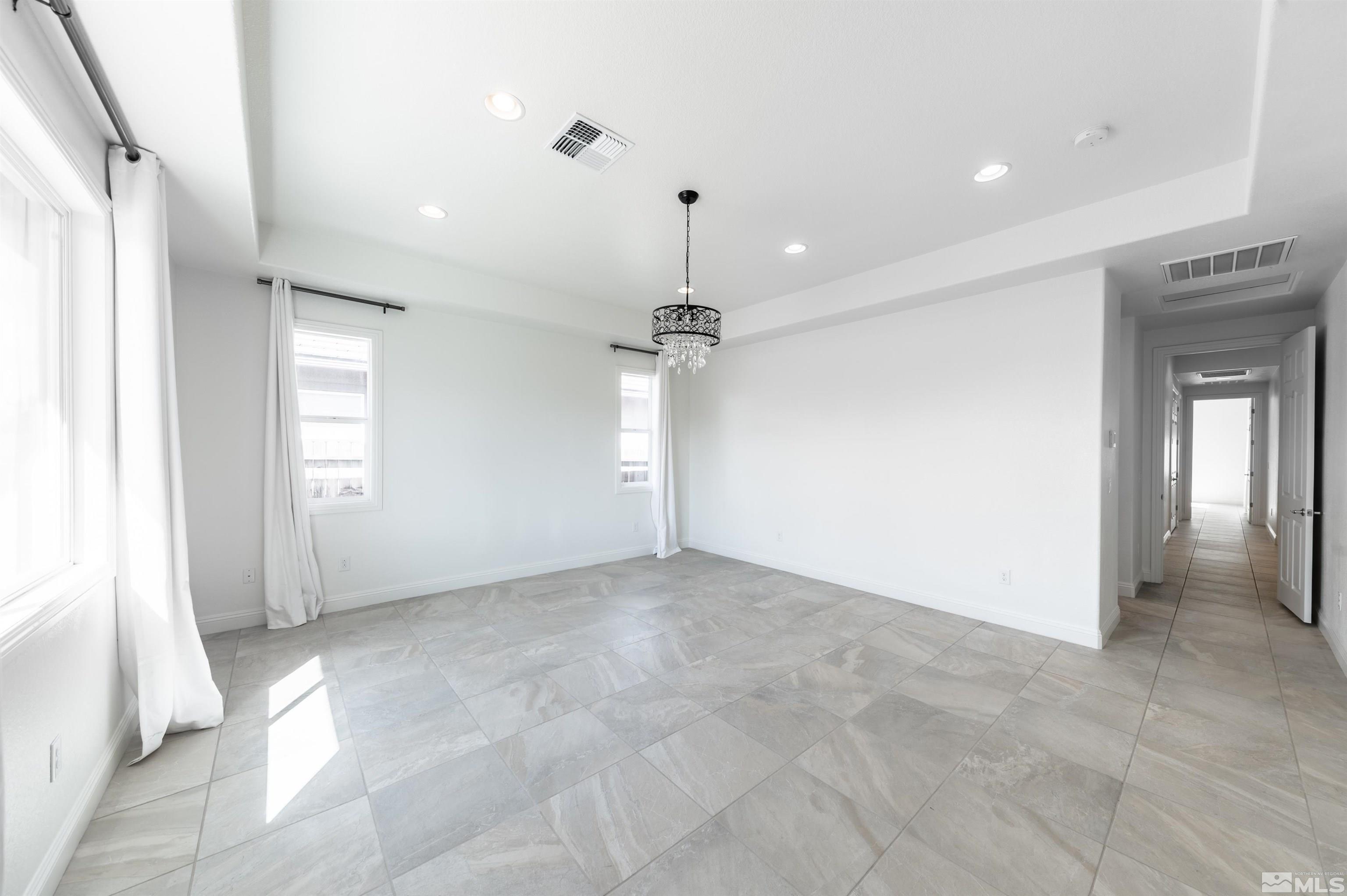 10065 Ellis Park Lane Reno, NV 89521 - Photo 15 of 30 an empty room with chandelier fan and windows