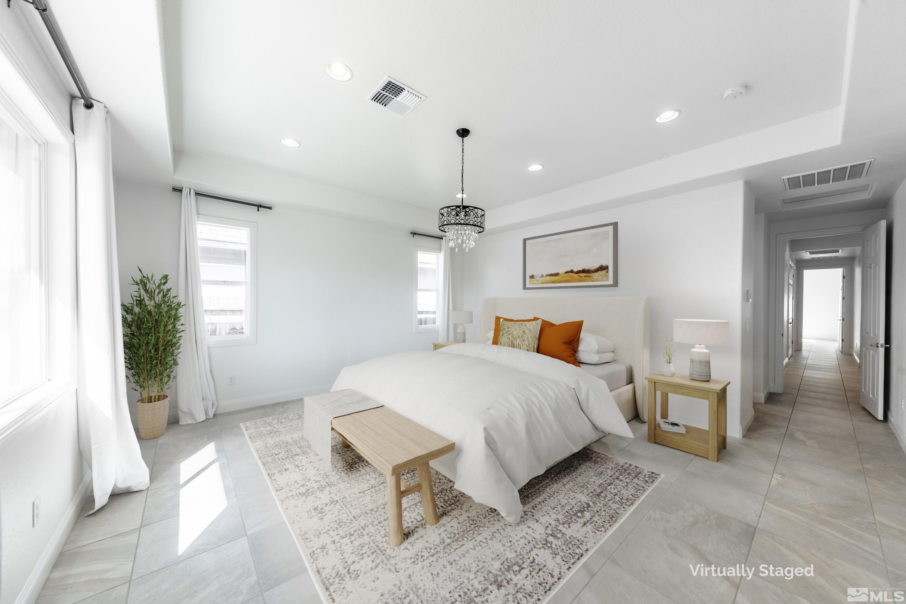 10065 Ellis Park Lane Reno, NV 89521 - Photo 16 of 30 a spacious bedroom with a large bed and a chandelier