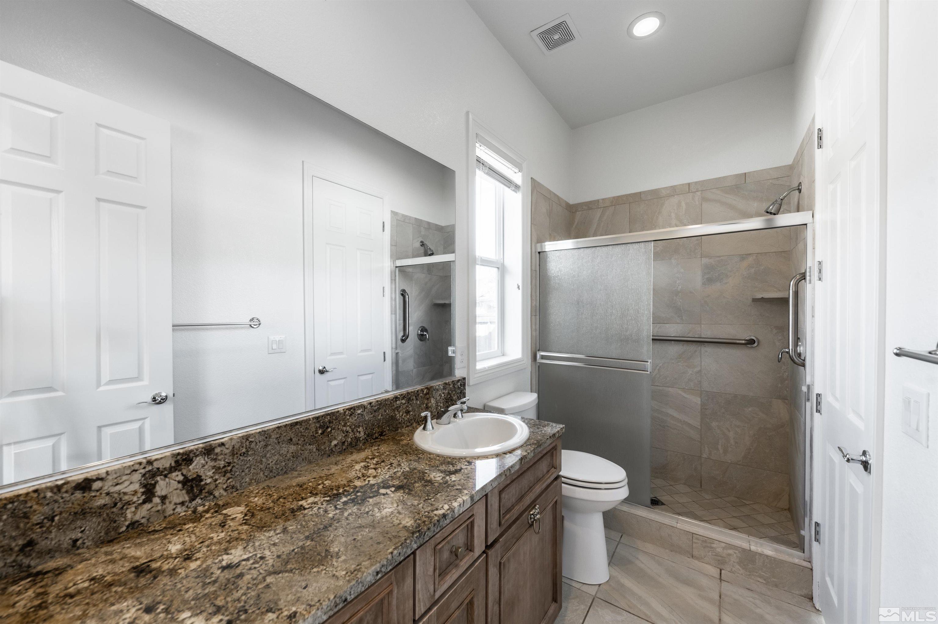 10065 Ellis Park Lane Reno, NV 89521 - Photo 22 of 30 a bathroom with a granite countertop sink toilet and shower