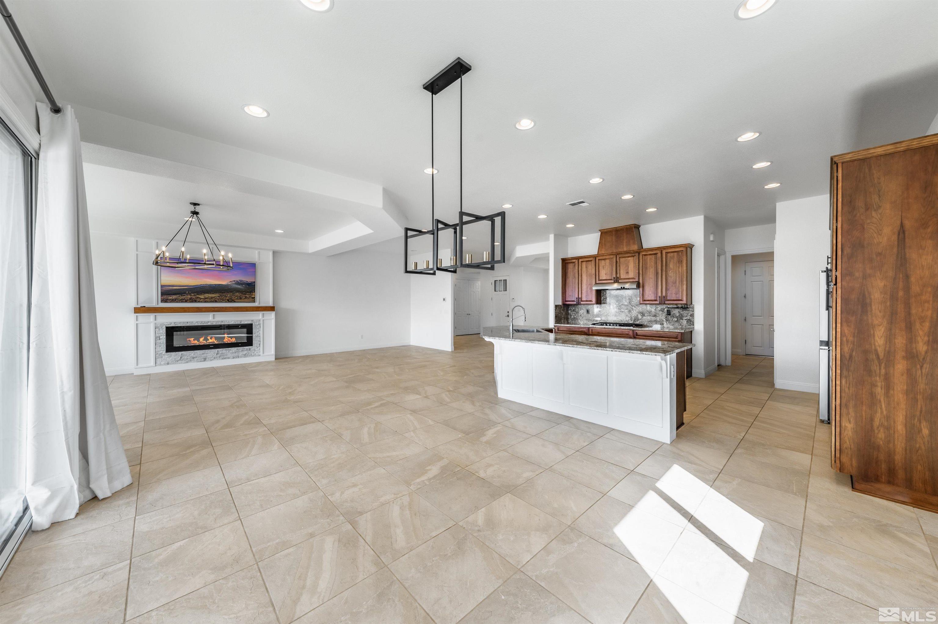 10065 Ellis Park Lane Reno, NV 89521 - Photo 10 of 30 a kitchen with stainless steel appliances kitchen island granite countertop a refrigerator a stove a oven and white cabinets with wooden floor