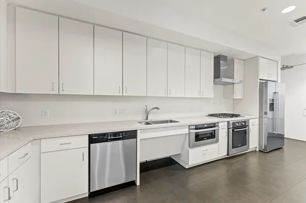 a kitchen with white cabinets and white appliances