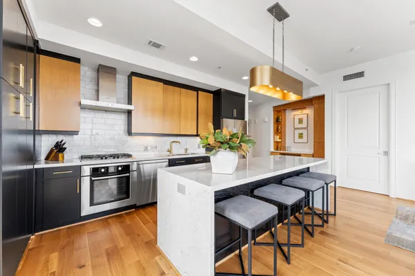 a kitchen with stainless steel appliances granite countertop a sink a stove and a refrigerator