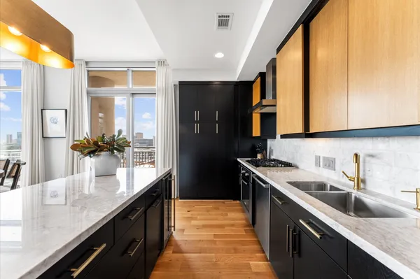 a kitchen with stainless steel appliances granite countertop a sink a stove and a refrigerator