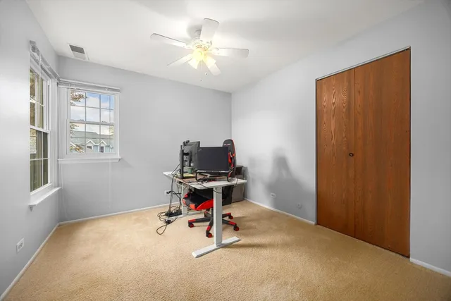a view of a workspace with furniture and a window