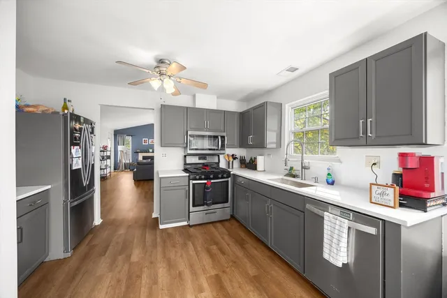 a kitchen with stainless steel appliances a stove refrigerator sink and microwave