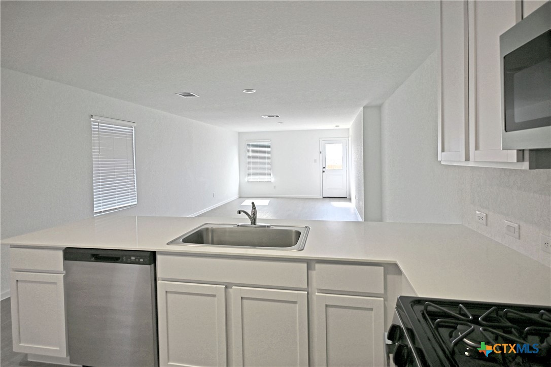 11560 Chestnut Rose St. Hedwig, TX 78152 - Photo 15 of 28 a kitchen with sink a stove and cabinets