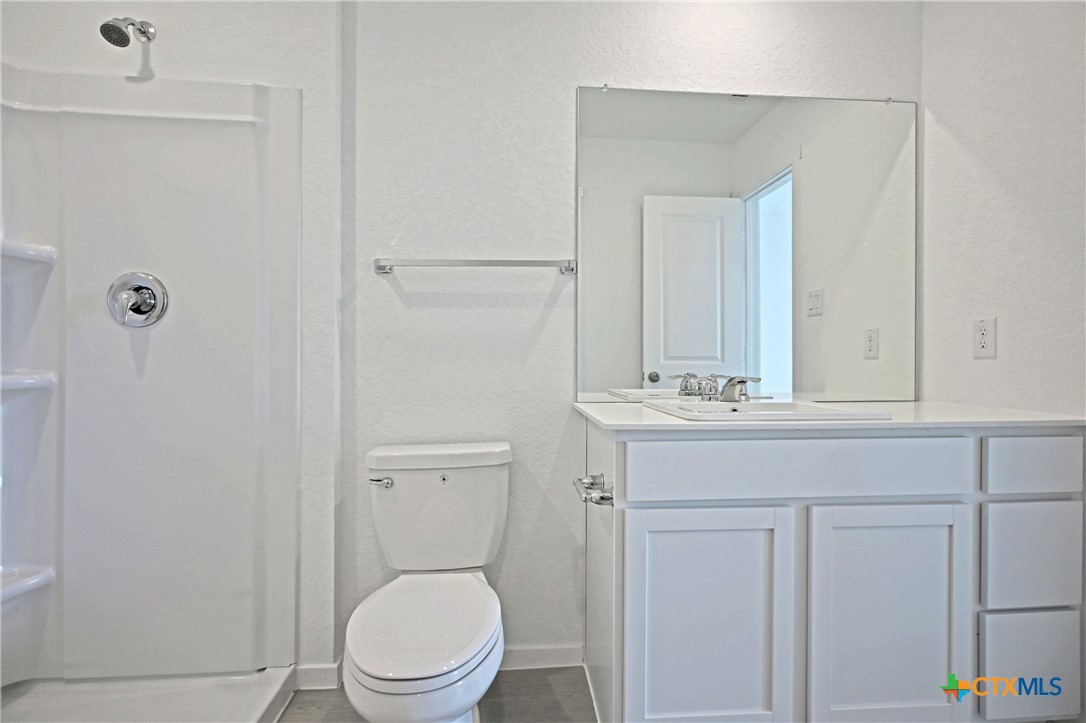 11560 Chestnut Rose St. Hedwig, TX 78152 - Photo 21 of 28 a bathroom with a sink a toilet and a mirror