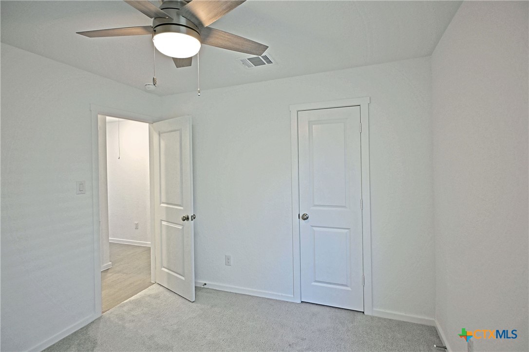 11560 Chestnut Rose St. Hedwig, TX 78152 - Photo 10 of 28 an empty room with a mirror and a ceiling fan