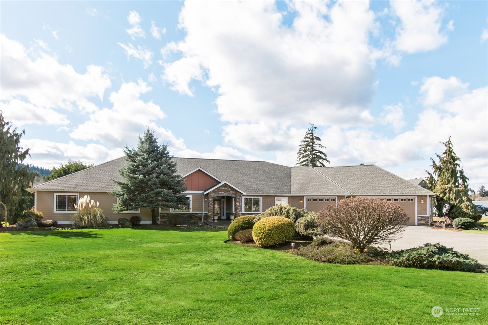 6504 263rd Street East Graham, WA 98338 - Photo 2 of 38 a front view of a house with a garden