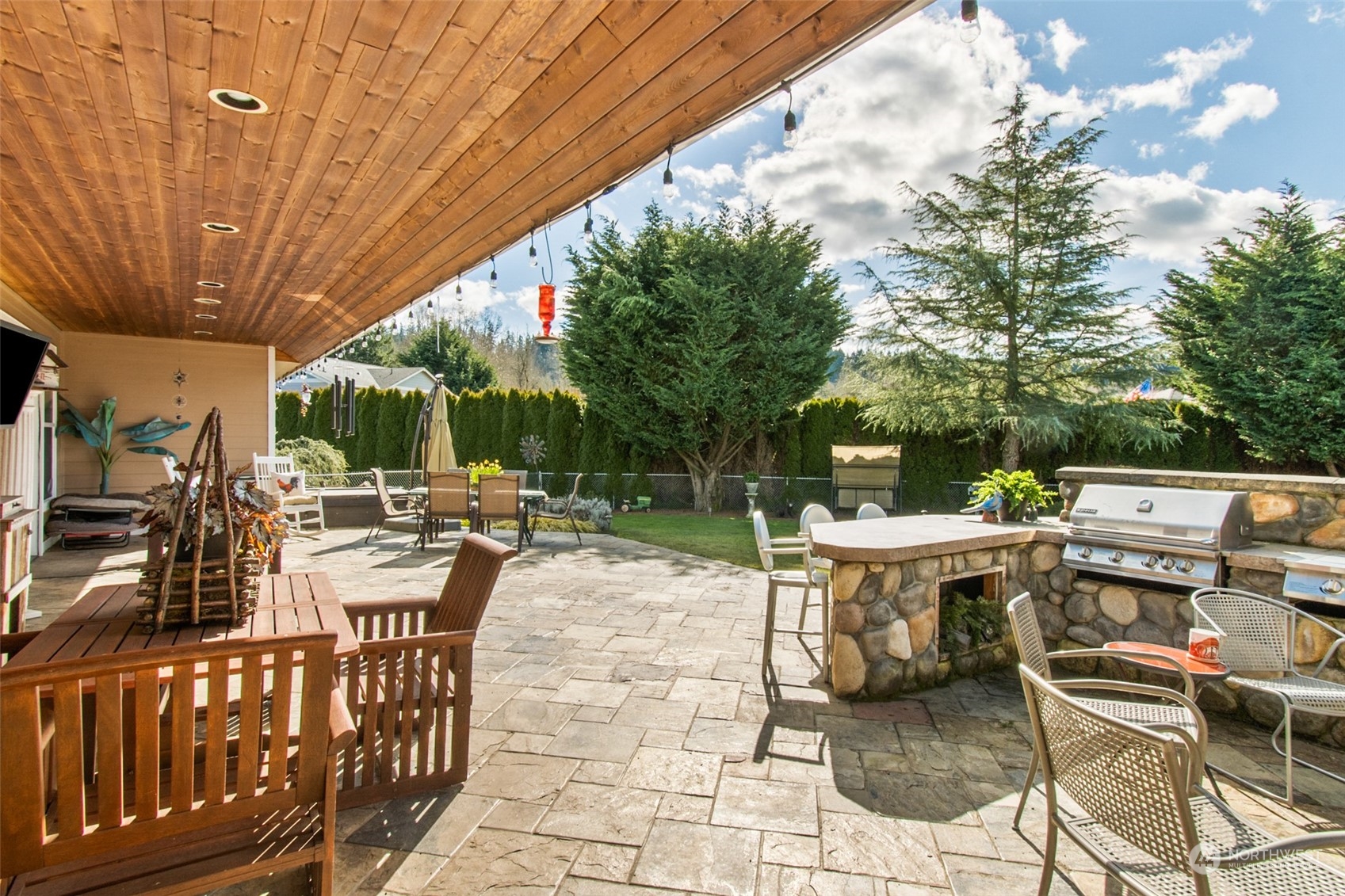 6504 263rd Street East Graham, WA 98338 - Photo 21 of 38 a view of a patio with a dining table and chairs with a small yard