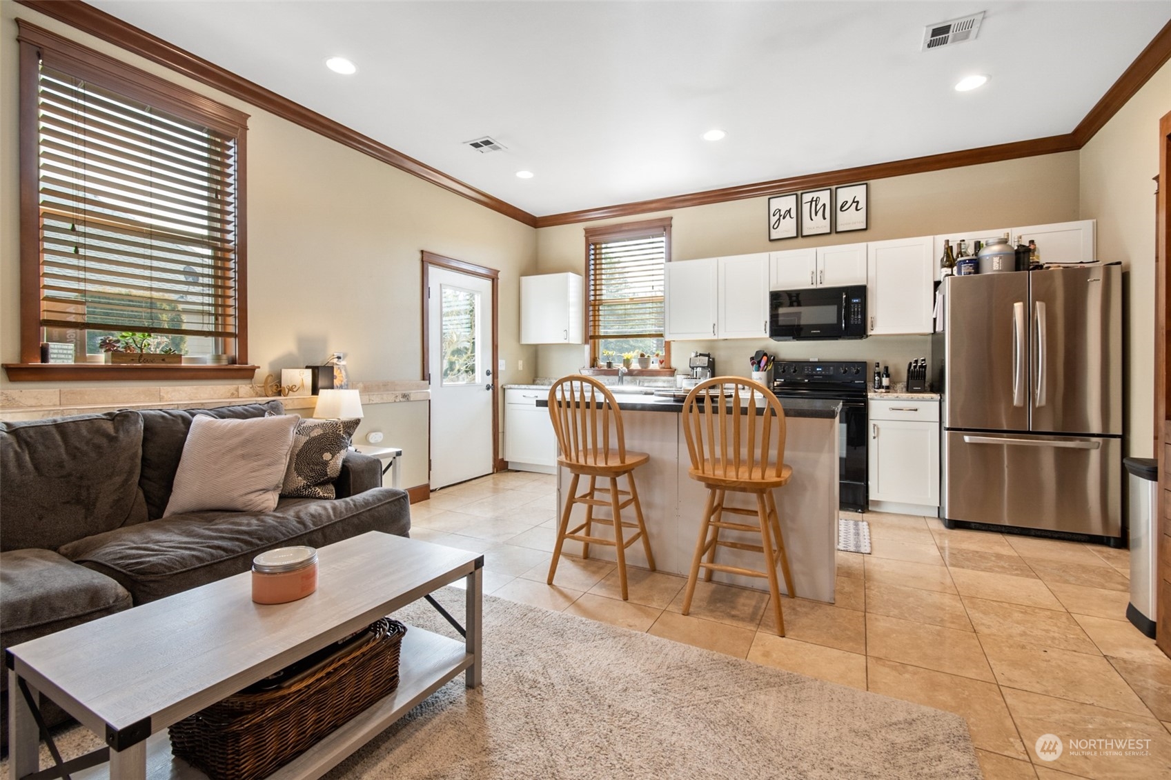 6504 263rd Street East Graham, WA 98338 - Photo 34 of 38 a living room with furniture a flat screen tv and a refrigerator