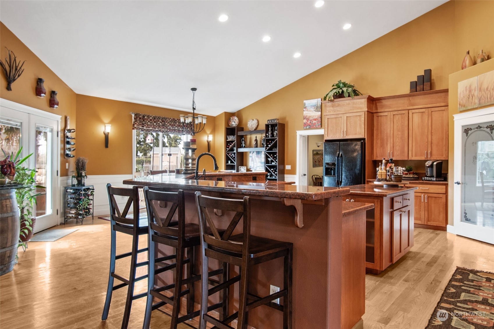 6504 263rd Street East Graham, WA 98338 - Photo 7 of 38 a kitchen with stainless steel appliances kitchen island granite countertop a table chairs sink and cabinets