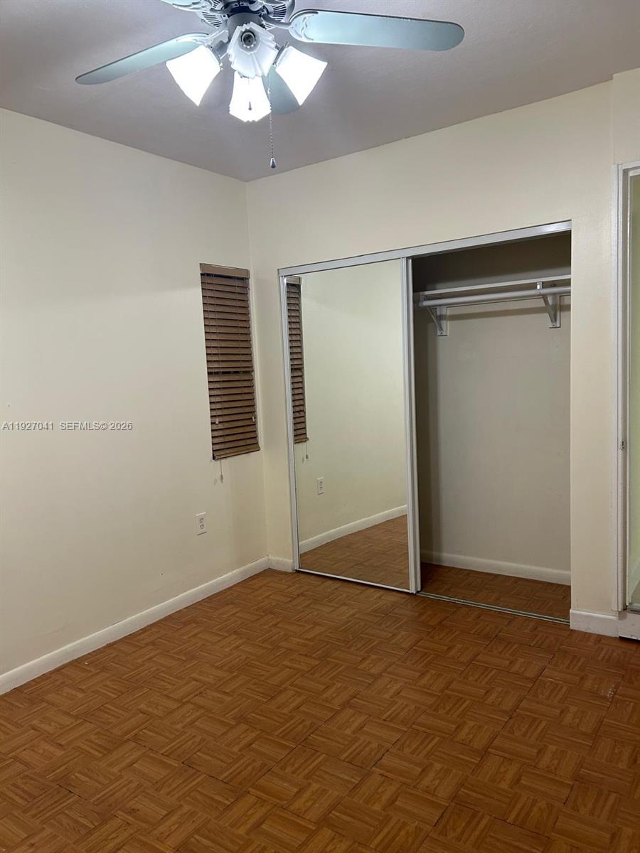 10011 Southwest 162nd Street Miami, FL 33157 - Photo 14 of 22 an empty room with a chandelier fan and windows