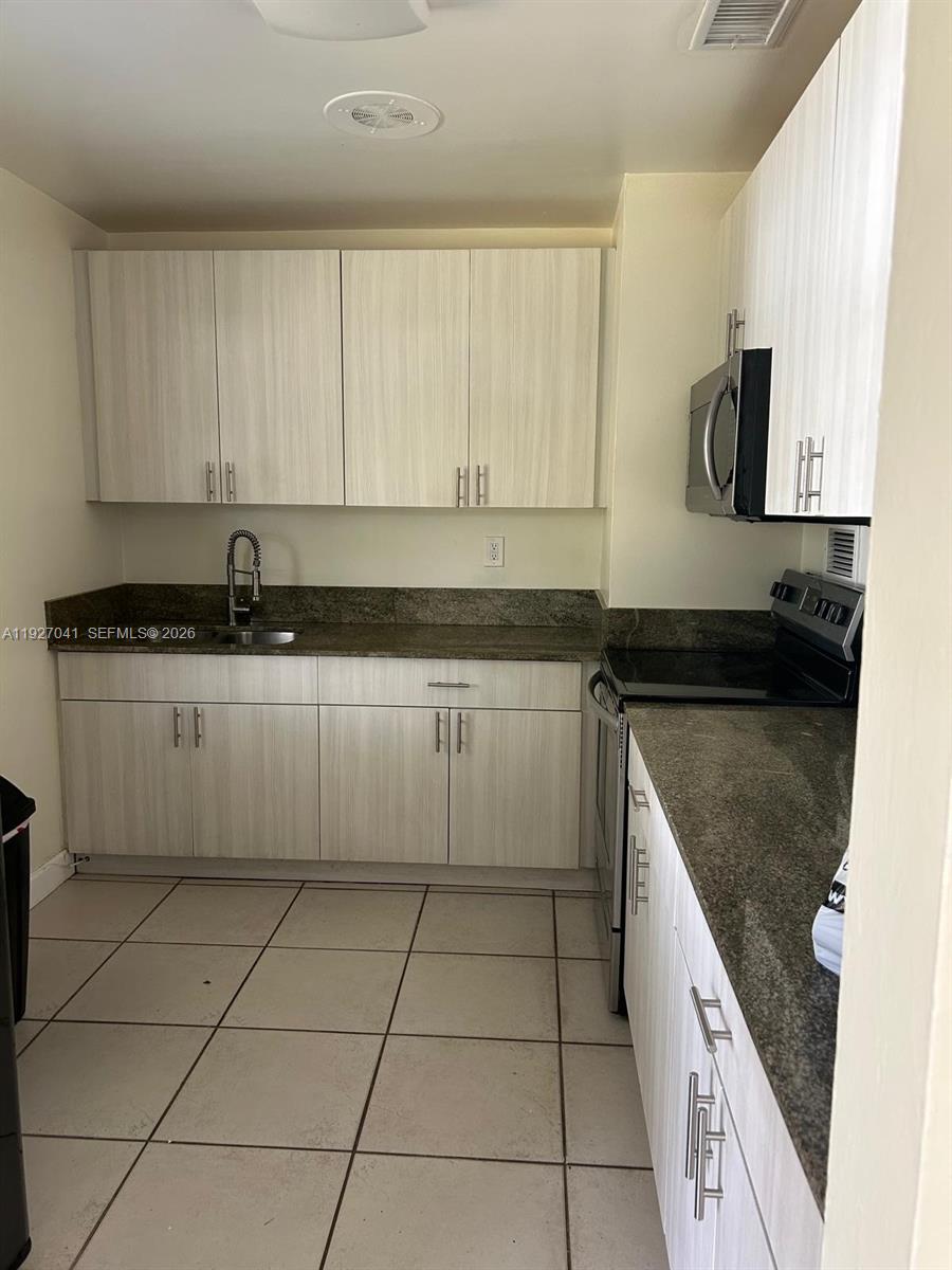 10011 Southwest 162nd Street Miami, FL 33157 - Photo 7 of 22 a kitchen with stainless steel appliances granite countertop a sink stove and cabinets