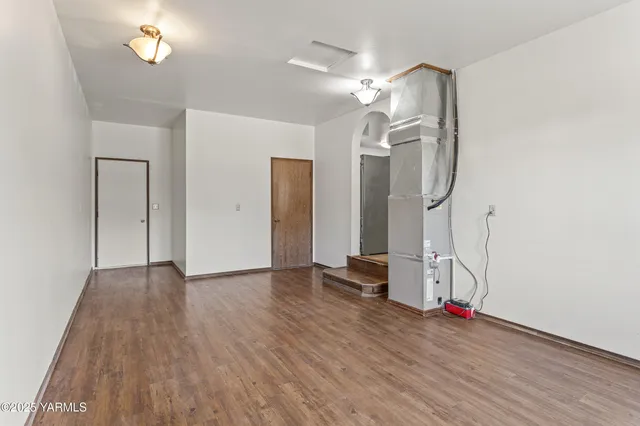 a view of empty room with wooden floor