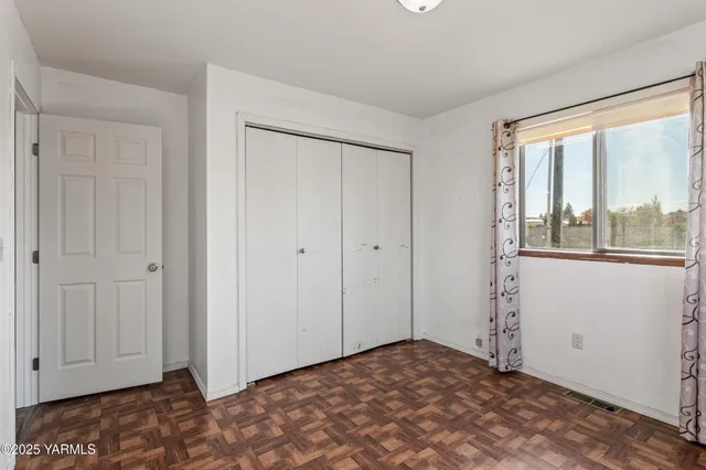 an empty room with a painting on the wall