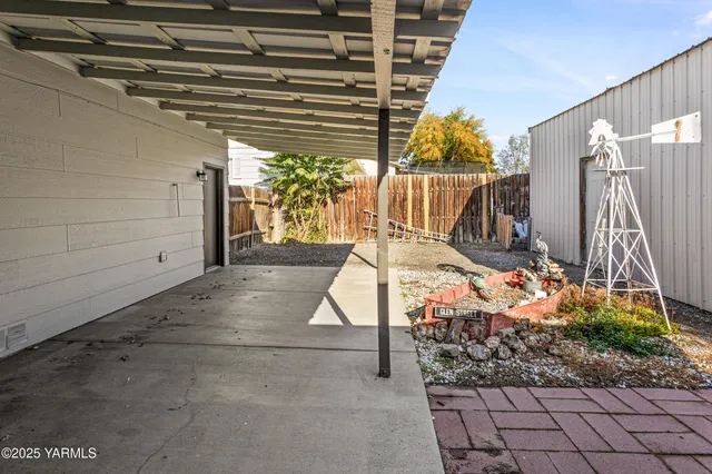 a backyard of a house with barbeque oven table and chairs
