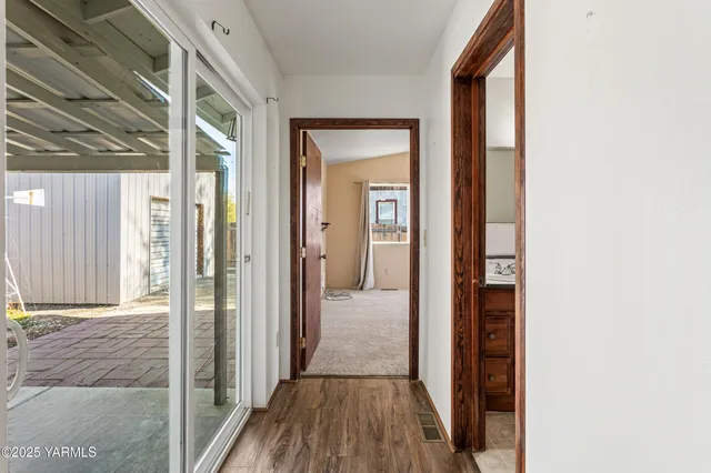 a view of a hallway with wooden floor