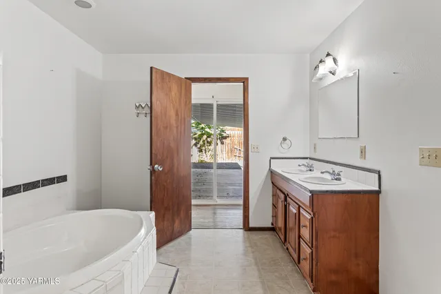 a bathroom with a tub sink and mirror