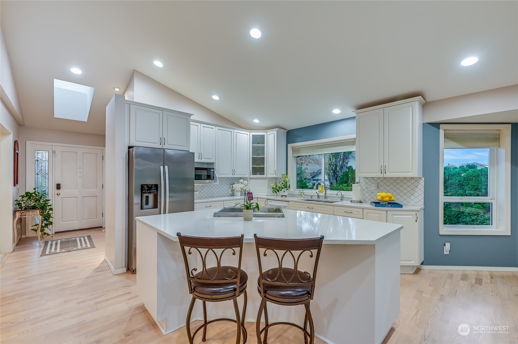 2504 240th Street Southeast Bothell, WA 98021 - Photo 9 of 40 a kitchen with stainless steel appliances a dining table chairs stove refrigerator and microwave