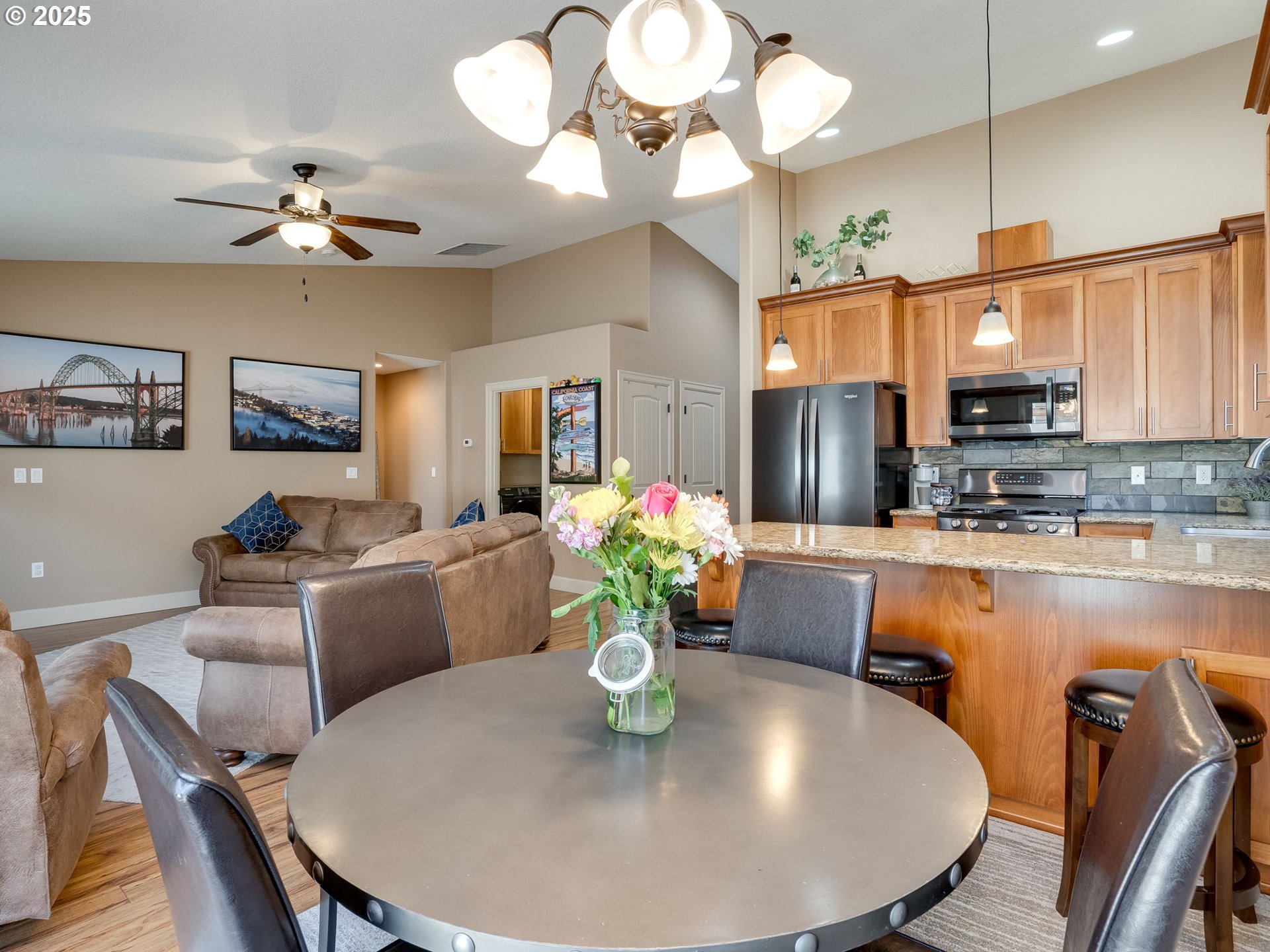 1047 Taurus Loop Northeast Keizer, OR 97303 - Photo 8 of 23 a view of a dining room with furniture a chandelier and wooden floor