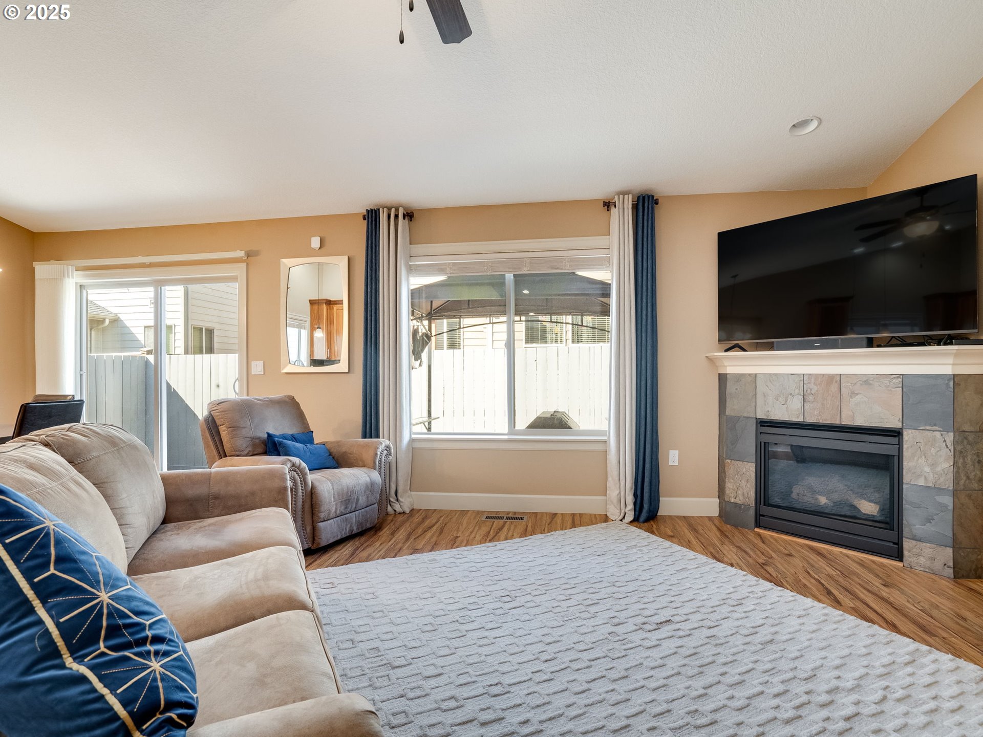 1047 Taurus Loop Northeast Keizer, OR 97303 - Photo 10 of 23 a living room with furniture a flat screen tv and a fireplace