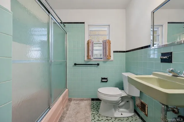 a bathroom with a toilet sink and mirror