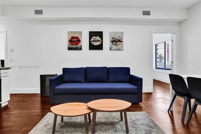 a living room with furniture a rug a lamp and a window