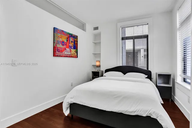 a bedroom with a bed and a painting on the wall