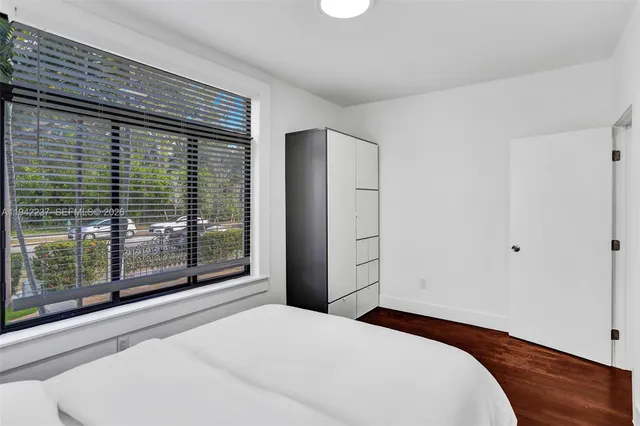 a bedroom with a bed and large window