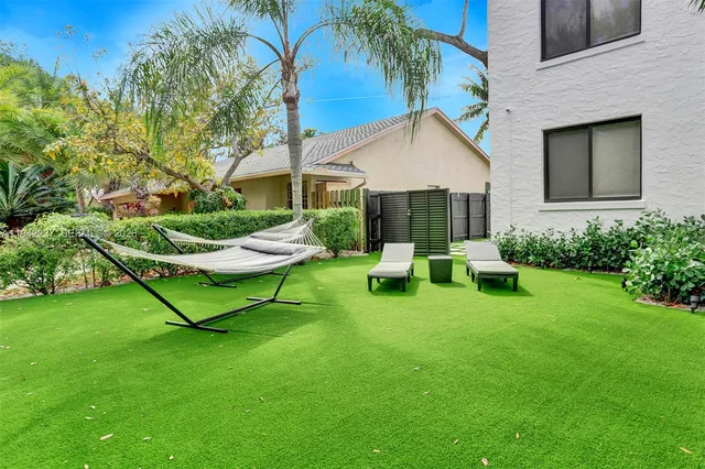 a view of a chair and table in backyard of the house