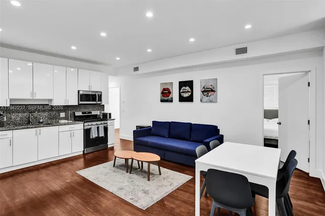 a living room with stainless steel appliances kitchen island granite countertop furniture and view of kitchen