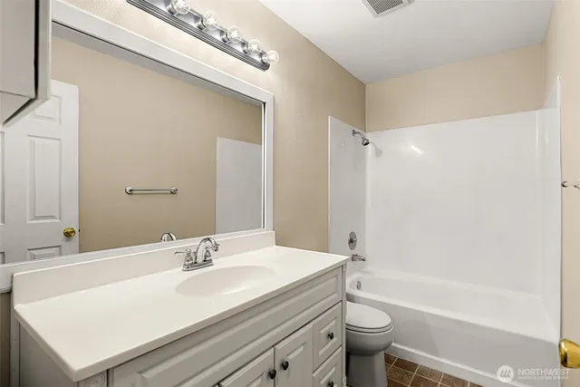 a bathroom with a sink a toilet and a large mirror