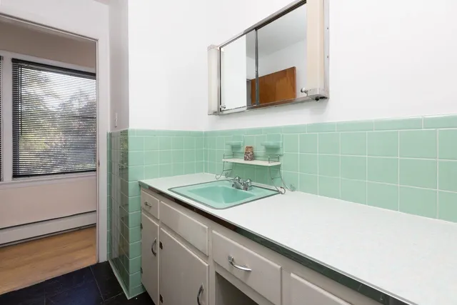 a bathroom with a mirror sink and toilet
