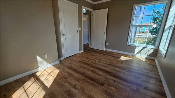 a view of a room with wooden floor and windows