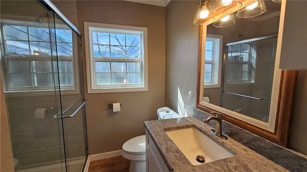 a bathroom with a sink a toilet and shower