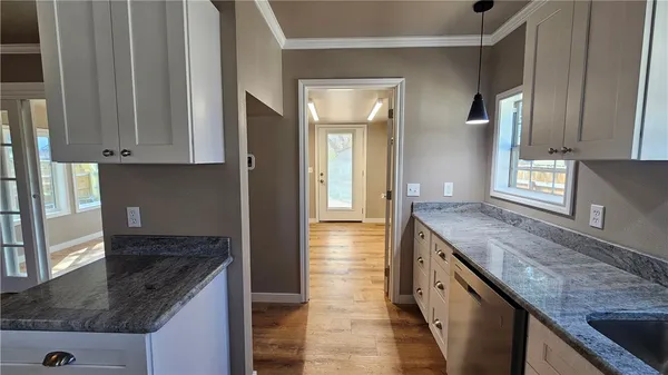 a kitchen with granite countertop a sink and a stove