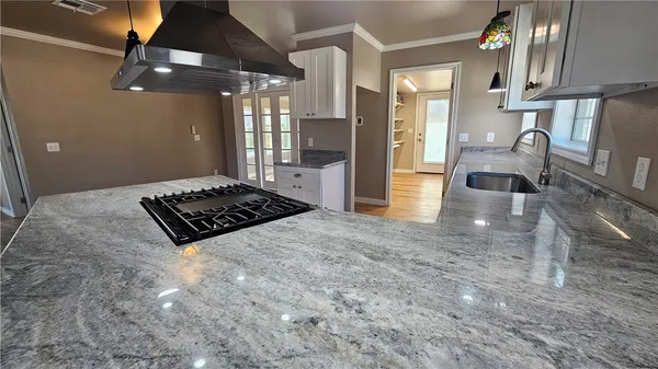 a kitchen with stainless steel appliances granite countertop a sink stove and cabinets