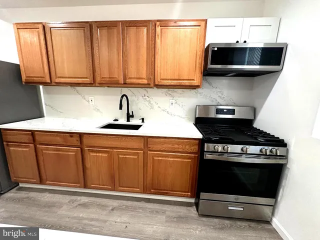 a kitchen with stainless steel appliances granite countertop a stove a sink and a microwave