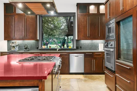 a large kitchen with stainless steel appliances kitchen island granite countertop a table and chairs
