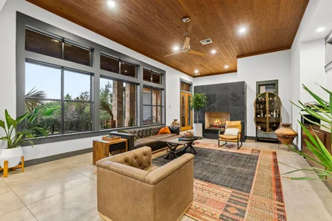 a living room with stainless steel appliances furniture and a large window
