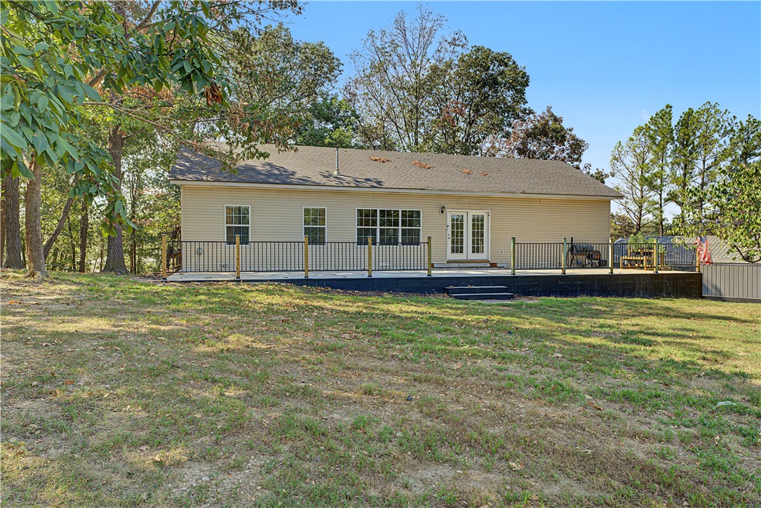 15282 Burgin Valley Road Gravette, AR 72736 - Photo 35 of 53 Charming single-story residence featuring a wraparound deck with white railings, multiple windows allowing natural light throughout, and a spacious grounds with mature trees