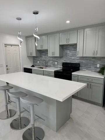 a kitchen with a sink a stove and chairs