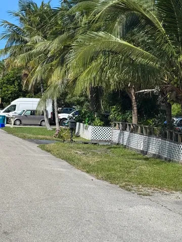 a car parked in front of a house with a big yard