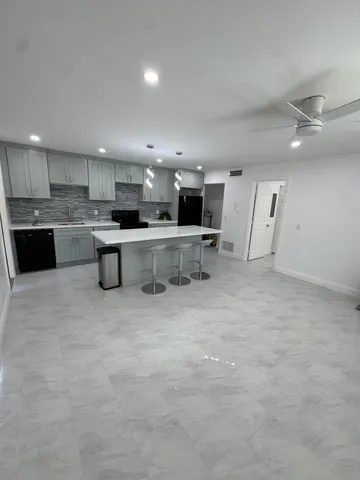 a large kitchen with a large counter top appliances and cabinets